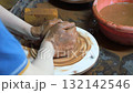 Close-up of children's hands sculpting ceramic dishes from clay in the workshop. 132142546