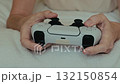 Young woman plays with video game controller 132150854