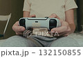 Young woman plays with video game controller 132150855