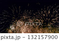 Synchronized firework shooting up and exploding in golden light like star dust filling the dark night sky 132157900