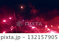 Colorful fireworks illuminate the night sky with pink and red hues forming a heart shape in celebration of Valentines Day 132157905