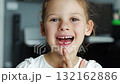 Close-up portrait of child smiling with missing baby tooth and pointing finger. A proud moment of growing up and celebrating childhood milestones. 132162886