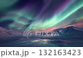 一道奇幻的綠色和紫色極光帶蔓延在白雪皚皚的山脈上 132163423
