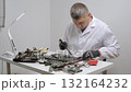 Engineer repairing electronic circuit board using soldering tool at desk 132164232