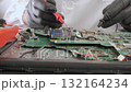 Technician testing electronic components on circuit board with precision tools 132164234