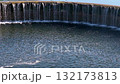 Circular weir on lippe river generating smooth waterfall cascading over engineered water management infrastructure during serene summer landscape in north rhine westphalia, germany 132173813