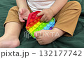 Child Engaged with Rainbow Pop-It Toy 132177742