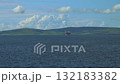 A merchant ship travels on a calm sea near the coast of Orkney 132183382