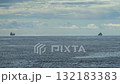 Two merchant ships travel in a calm sea, cloudy sky at sunset 132183383
