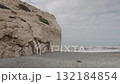Rocky beach and sea waves under cloudy sky on a misty morning 132184854