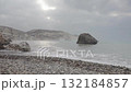 Rocky beach and sea waves under cloudy sky on a misty morning 132184857