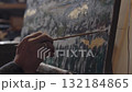 Senior artist on a wheelchair paints an oil painting on canvas in a studio 132184865