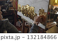 Senior artist on a wheelchair applies gold to the oil painting 132184866