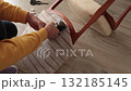 Anonymous person restore old vintage chair in home. Fabric replacement. Antique furniture and modern striped linen and cotton fabric. Hobbies, crafts, and retro-minimalist style. 132185145