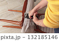 Anonymous person restore old vintage chair in home. Fabric replacement. Antique furniture and modern striped linen and cotton fabric. Hobbies, crafts, and retro-minimalist style. 132185146
