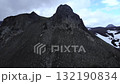Aerial view flying towards barren volcanic mountain peak. Media 132190834