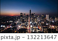 Vertical time-lapse of a modern city skyline transitioning from sunset to night. Illuminated skyscrapers and traffic light trails in a bustling metropolis. Urban progress and city life concept Vertical time-lapse of a modern city skyline transitioning from sunset to night. Illuminated skyscrapers and traffic light trails in a bustling metropolis. Urban progress and city life concept 132213647