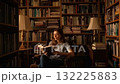 A Woman Engrossed in Literature: Captivating Moments in a Serene Library Setting with Shelves Full of Books and Cozy Atmosphere. 132225883