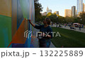 Artist Engaged in Vibrant Mural Painting in Urban Park, Showcasing Colorful Geometry Against City Skyline and Engaging Community Atmosphere. 132225889