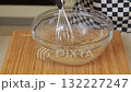 Mixing brown sugar with milk whisking dough in a glass bowl 132227247