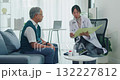 Young Asia female doctor with old man patient use clipboard for consulting, advice and medical expert on sofa in health clinic office. Help, appointment support in hospital for diagnosis, physician. 132227812