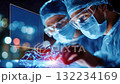 Medical professionals observing a glowing robotic hand during a futuristic operation 132234169