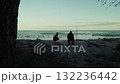 Silhouette of two people watching the strong ocean waves crash in the morning 132236442