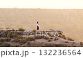 Muslim woman standing on a cliff overlooking the desert 132236564