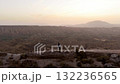 Aerial view of couple walking on desert cliff during sunset 132236565