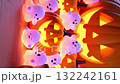 The chubby little ghosts emit a soft glow behind and around the big smiling pumpkin 132242161