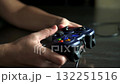 Person's hands skillfully operate a modern video game controller, immersed in a digital world. Enjoy the focused concentration and interactive entertainment of gaming. 132251516