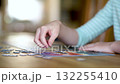 Close-up slow motion view of young woman hands assembling puzzles at home. 132255410