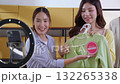 Two young asian woman live streaming online clothing store while showing clothing with smartphone. 132265338