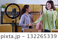 Two young asian woman live streaming online clothing store while showing clothing with smartphone. 132265339