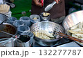 A chef is frying squid rings in a pan 132277787