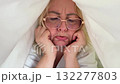 Mature woman with glasses showing mixed emotions, removes glasses, covers face with hands, then smiles and plays peekaboo, expressing real human feelings 132277803