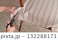 Anonymous person restore old vintage chair in home. Fabric replacement. Antique furniture and modern striped linen and cotton fabric. Hobbies, crafts, and retro-minimalist style. 132288171
