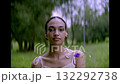 Beautiful young woman in pretty with blue flowers in her hand in park, summer 132292738