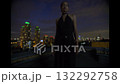 Beautiful young woman in black suit the night on the roof of down town building 132292758