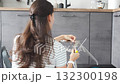 Young woman seen from behind assembling a chair with screwdrivers on the floor at home. Concept of modern lifestyle and practical skills in everyday life. 132300198