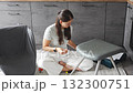 Young woman sitting on the floor assembling a chair with tools. Concept of female independence and do it yourself lifestyle. 132300751