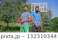Portrait of athletic handsome African American male basketball players with ball looking with friendly smiles on outdoor basketball court, expressing positivity and confidence. Portrait of athletic handsome African American male basketball players with ball looking with friendly smiles on outdoor basketball court, expressing positivity and confidence. 132310344