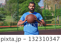 Portrait of athletic bearded African American male basketball player holding basketball between hands on outdoor court, expressing determination, confidence and readiness for competition. Portrait of athletic bearded African American male basketball player holding basketball between hands on outdoor court, expressing determination, confidence and readiness for competition. 132310347