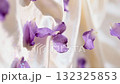 Purple petals slowly fall on the silk fabric 132325853