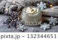 Lavender cream jar on knitted sweater with snowflakes and dried flowers in cozy winter setting 132344651