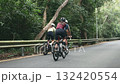 rear view of three asian cyclists training on a uphill country road	 132420554