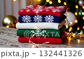 Hand reaching for cozy knitted sweater in festive holiday setting with warm lights 132441326