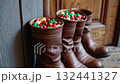 Christmas boots overflowing with candy near rustic wooden door for holiday cheer 132441327