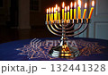 Glowing menorah on blue tablecloth captures light and tradition in vibrant celebration 132441328