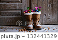 Festive winter boots overflowing with colorful gift decorations by rustic wooden door 132441329